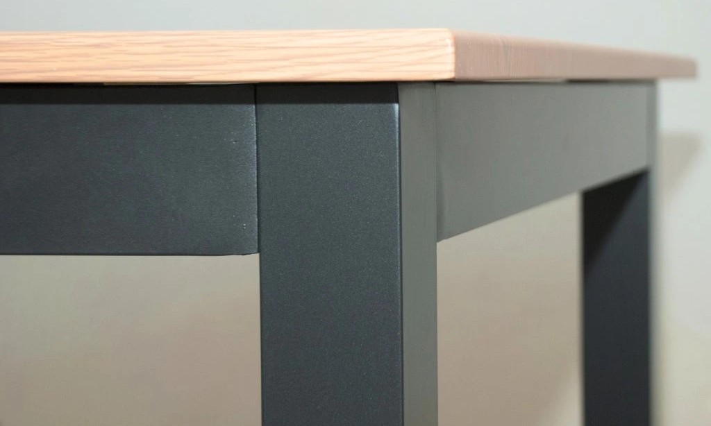 Detail rohu zahradního stolu EXPERT WOOD od Doppler — hliníková deska s povrchem v dekoru dřeva a tmavý kovový rám