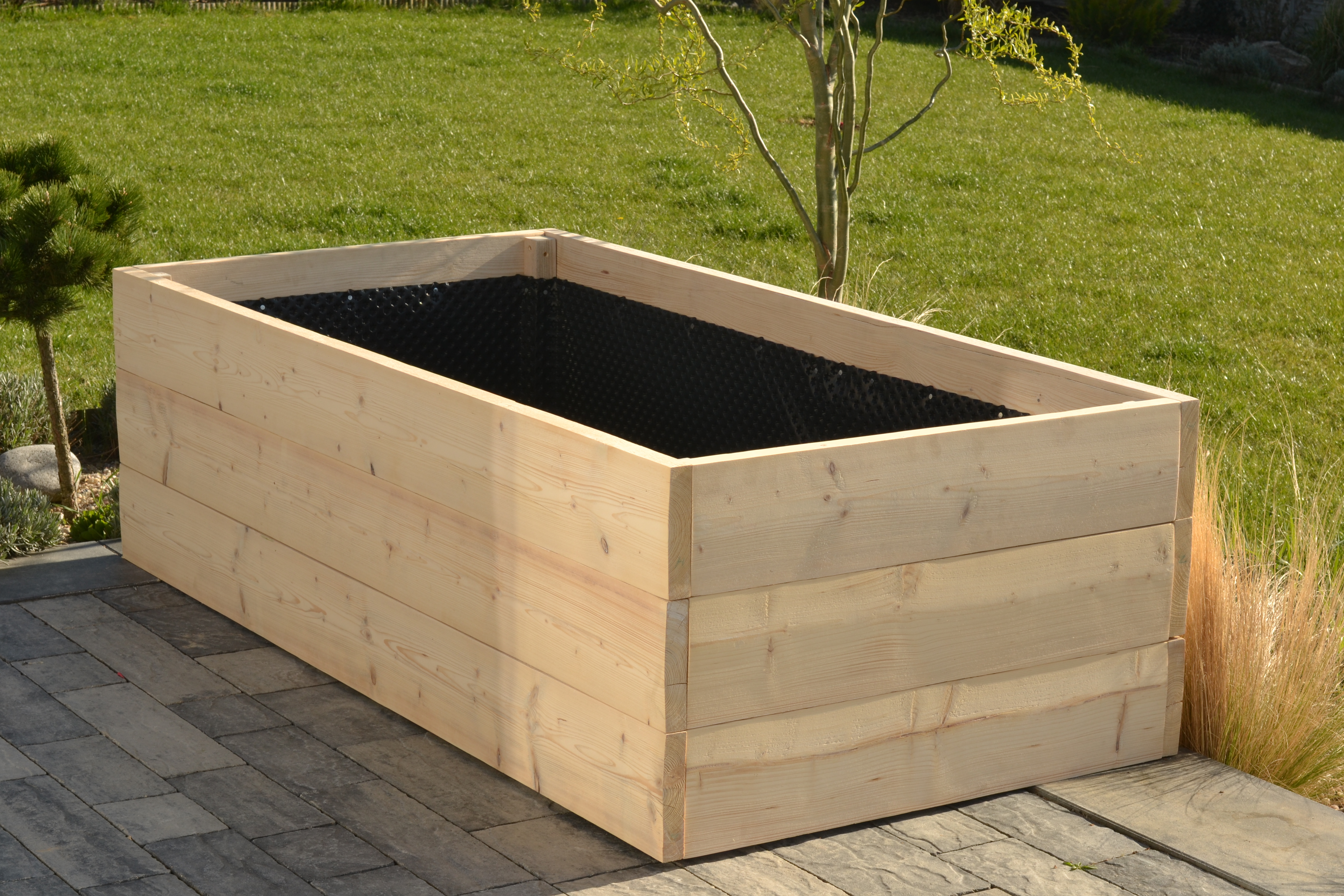 Vyvýšený záhon z masivních fošen s ochranným pletivem na dně