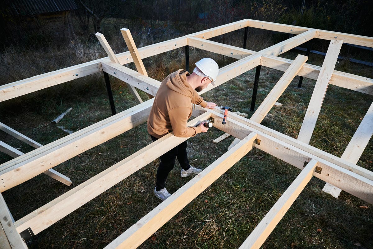 man-worker-building-wooden-frame-house-on-pile-fou-2025-01-16-22-58-25-utc