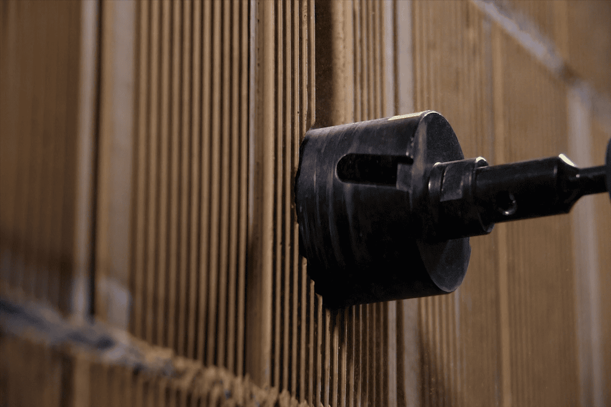 Makro detail vŕtania dutým korunkovým vrtákom do rebrovanej tehly Porotherm