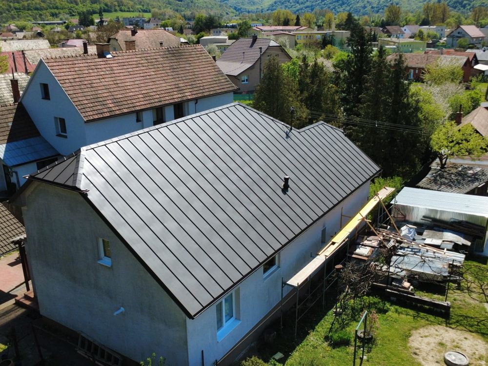 Svetlá plechová falcovaná strecha rodinného domu z dronu