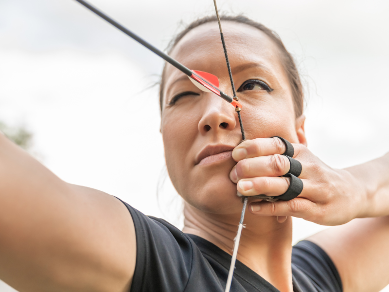 Na fotografii je žena, která napíná tětivu s šípem a soustředí se na cíl. Obrázek symbolizuje koncentraci, mentální sílu a jasnou mysl – účinky Cordycepsu na mozek a psychickou rovnováhu.