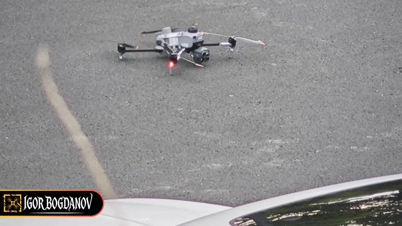 Údajný prototyp DJI Matrice 5 na mokrém asfaltu s vysokým podvozkem a vícesenzorovým gimbalem