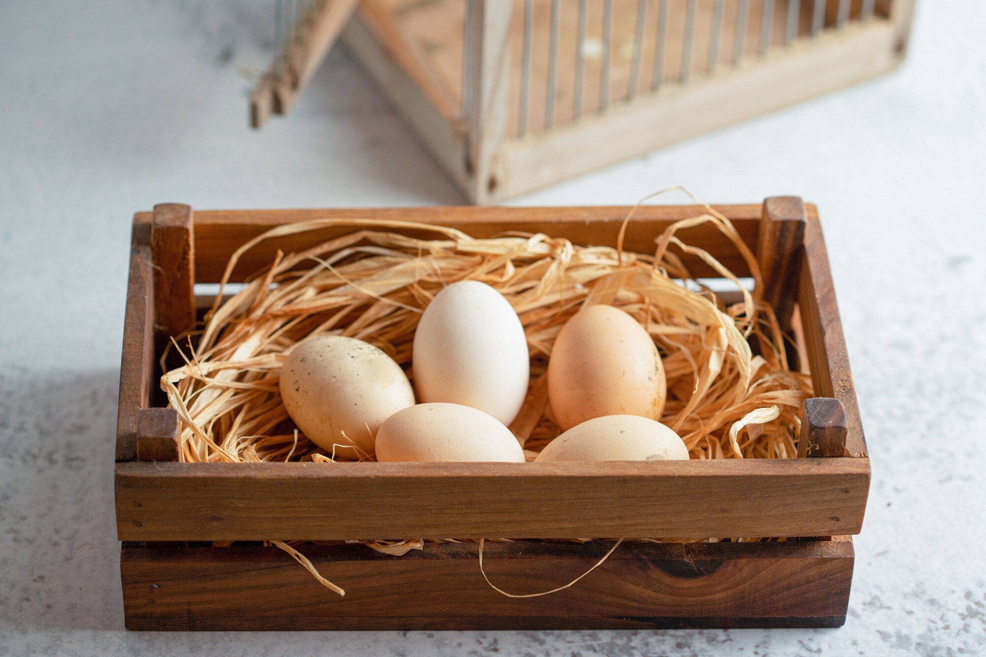 close-up-photo-fresh-organic-chicken-eggs-straw-wooden-box_114579-80593