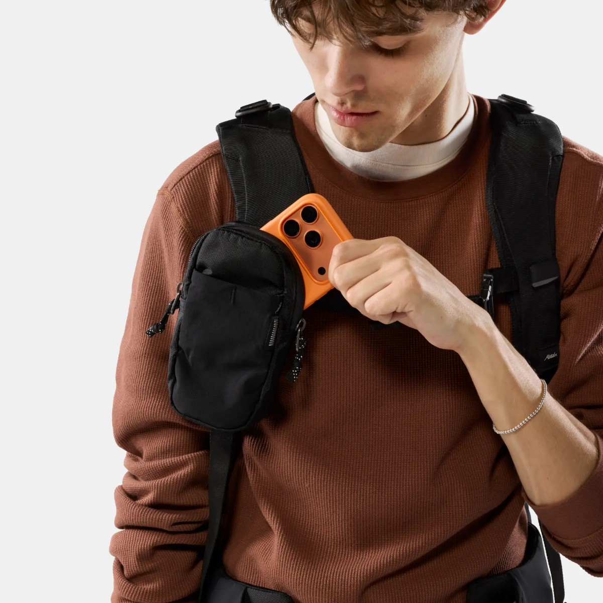 Přídavná kapsa připevněná na ramenním popruhu batohu s telefonem uvnitř