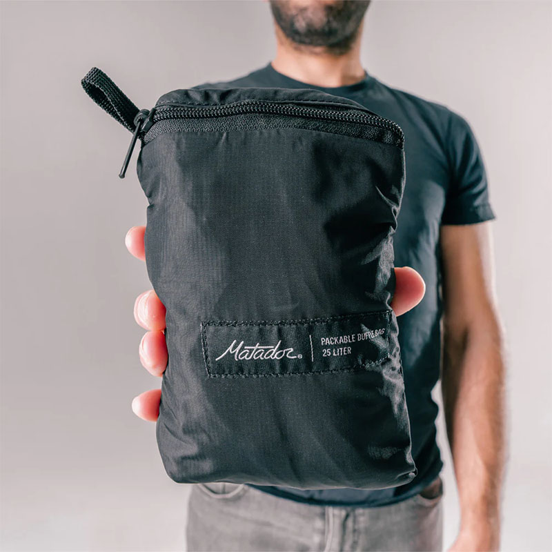 Matador skladacia cestovná taška ReFraction™ 25l Farba: Čierna.
ReFraction™ Packable Duffle&nbsp;ponúka dostatok úložného priestoru pre všetky vaše nevyhnutnosti a kúpené suveníry.&nbsp;Vďaka odolnému a ľahkému materiálu odoláva náročným podmienkam, či už ste na cestách alebo dobrodružstvo v prírode.&nbsp;Je možné ju využiť všade, kde potrebujete rýchlo dostupný úložný priestor.&nbsp;Vhodná je teda aj pre cesty na nákupy, do fitka alebo napríklad v lete k vode.
Taška je vyrobená z recyklovateľného a&nbsp;vodeodolného 100D nylonu a je PFC free.&nbsp;Doplnená je o&nbsp;&nbsp;YKK® zipsy, ktoré zaisťujú jej vodeodolnosť pri zapínaní.&nbsp;Na vrchu tašky je dlhý zips, ktorý umožňuje rozopnutie po celej dĺžke tašky, takže robí obsah ľahko dostupný.&nbsp;Z vonkajšej strany tašky sú dve menšie ľahko prístupné priehradky, do ktorého je možné vložiť maličkosti, ktoré chcete mať vždy po ruke.&nbsp;Súčasťou tašky je odopínateľný popruh cez rameno s nastaviteľnou dĺžkou.&nbsp;