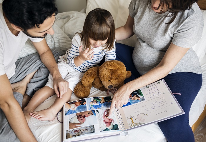 pregnant-family-looking-through-a-family-photo-PDPRVHS