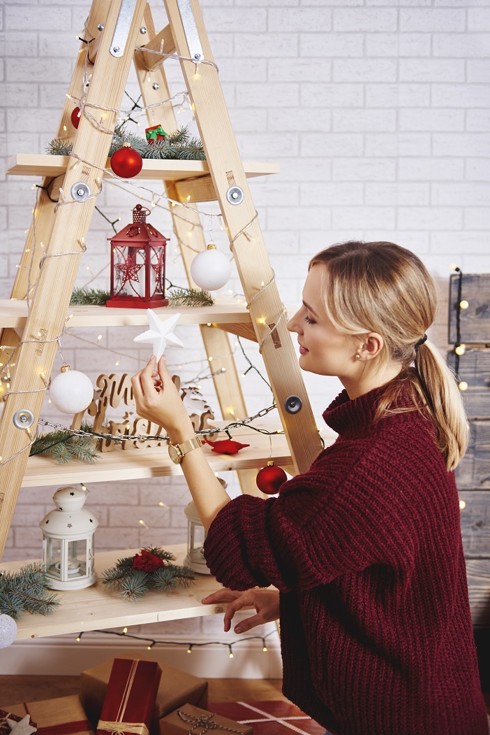 young-woman-decorating-the-christmas-tree-GDUKA7C