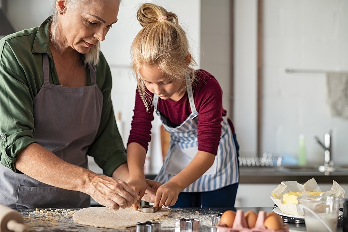 girl-with-grandmother-preparing-cookies-7CN4Y9R