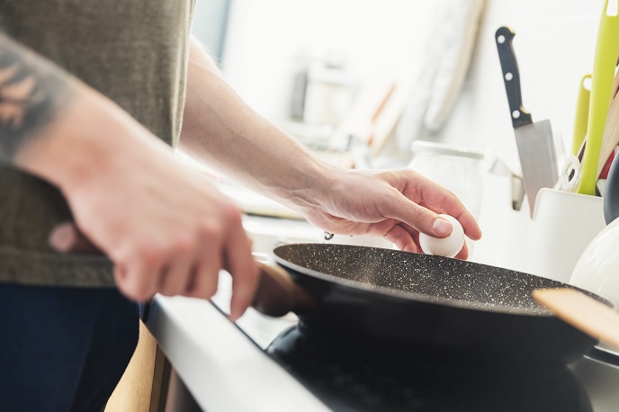 man-preparing-fried-eggs-in-the-kitchen-P3QE5HN