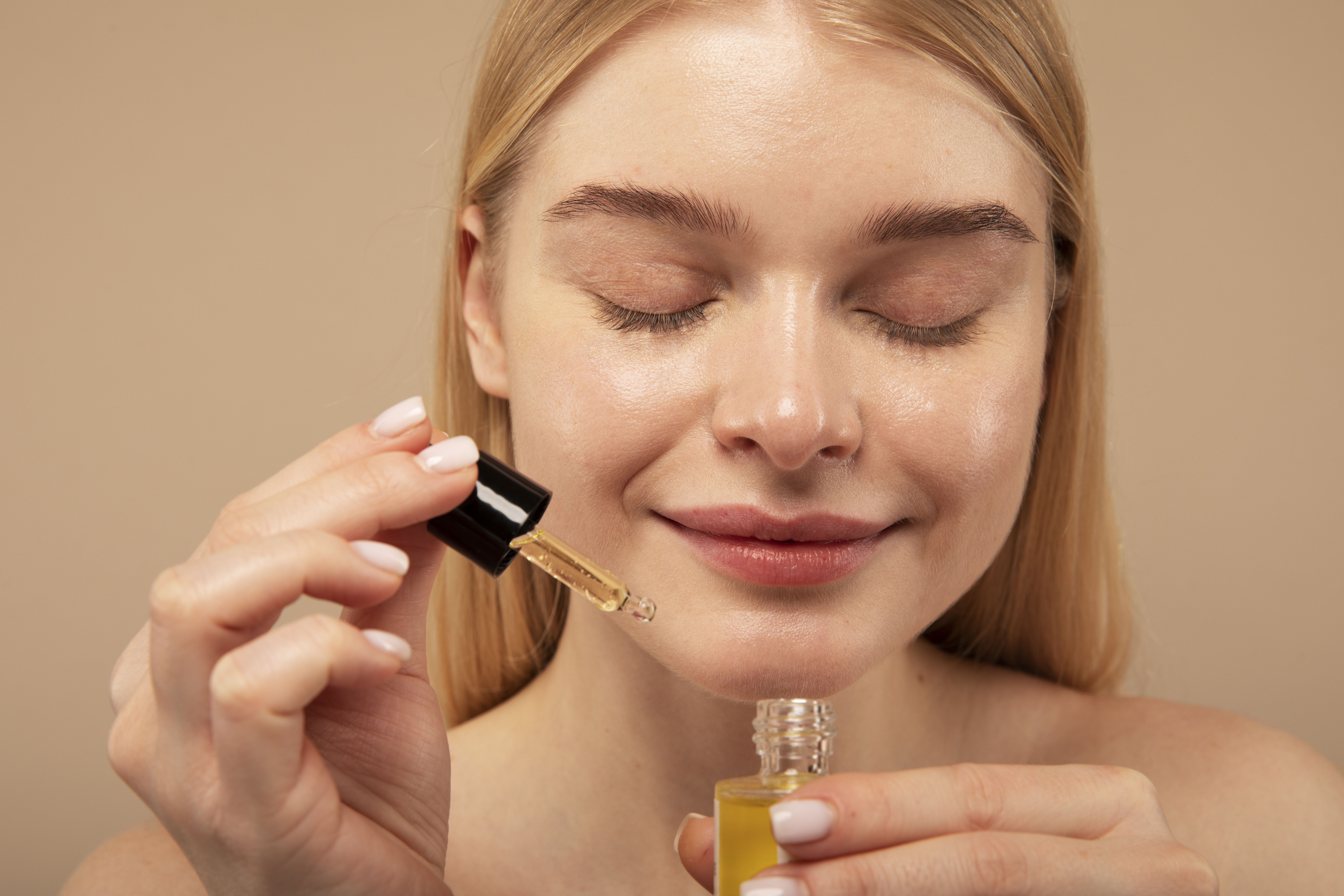 close-up-smiley-woman-holding-serum
