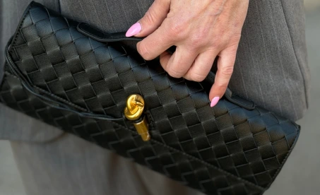 čierna kožená listová kabelka s prepletanou štruktúrou a zlatým zapínaním