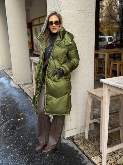 Zelená dlhá zimná bunda na žene v jesennom mestskom outfite.