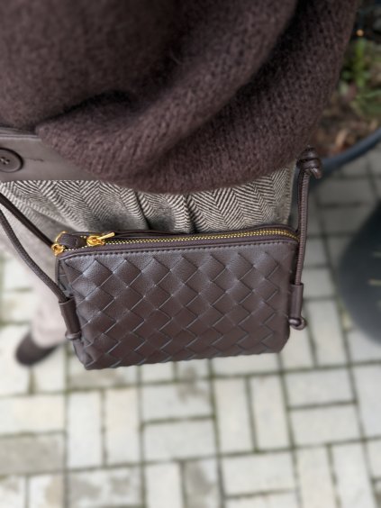 Hnedá mini pletená kabelka so zlatým zipsom a tenkým crossbody remienkom.