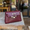 Bordová kožená mini kabelka so zlatým zapínaním, elegantný doplnok v burgundy odtieni