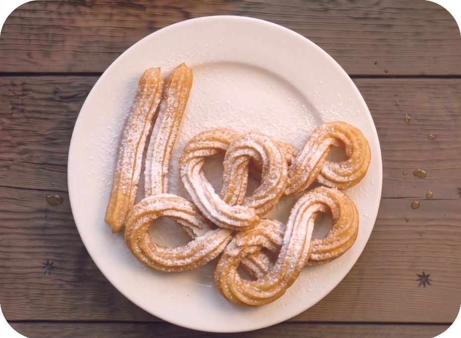 Pocukrované churros na bielom tanieri