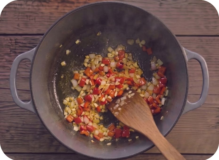 Hrniec, v ktorom sa restuje nakrájaná cibuľa, cesnak a paprika