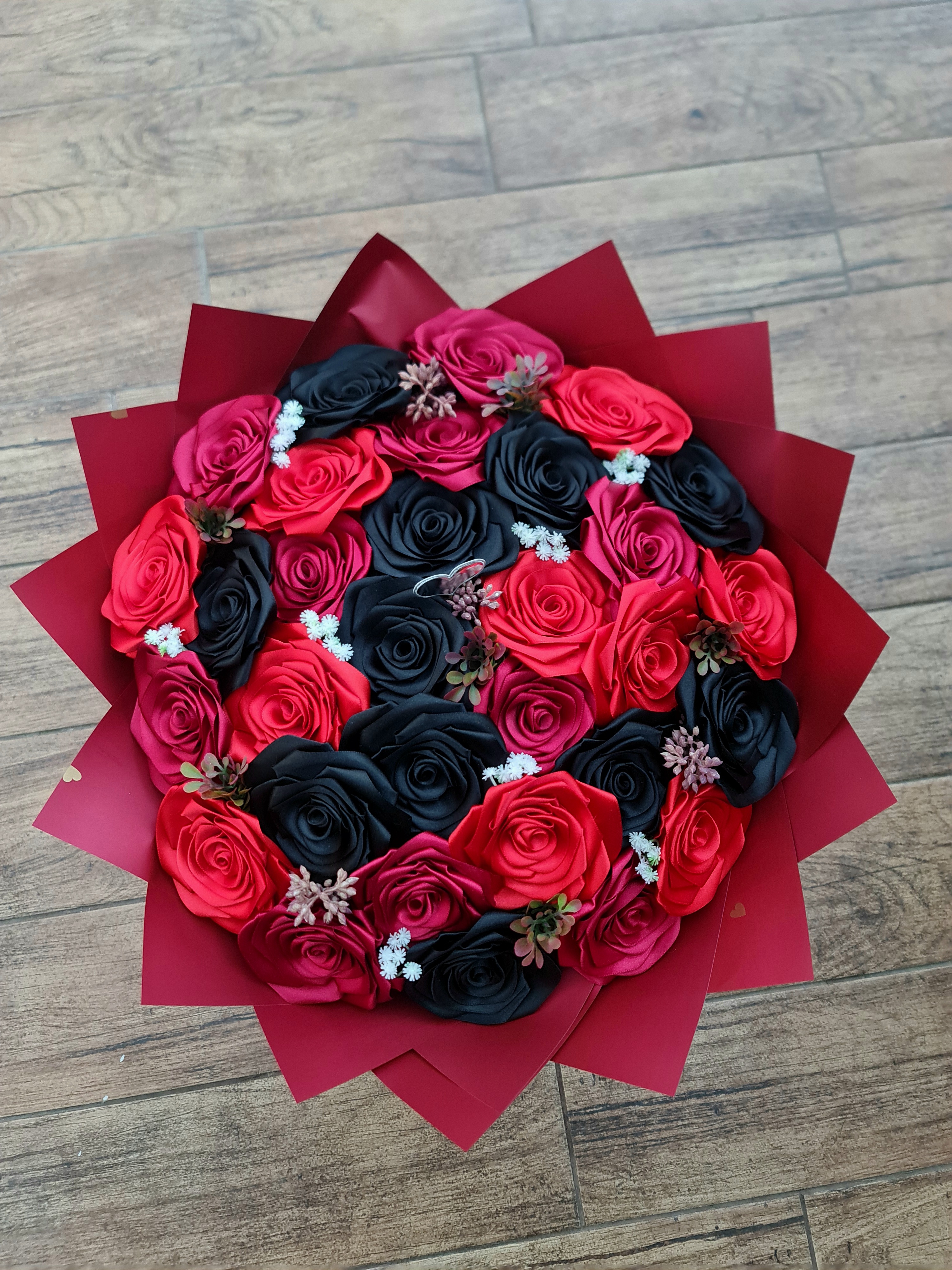Netradiční kytice ze stuh v kontrastní červeno-černé kombinaci se saténovými růžemi