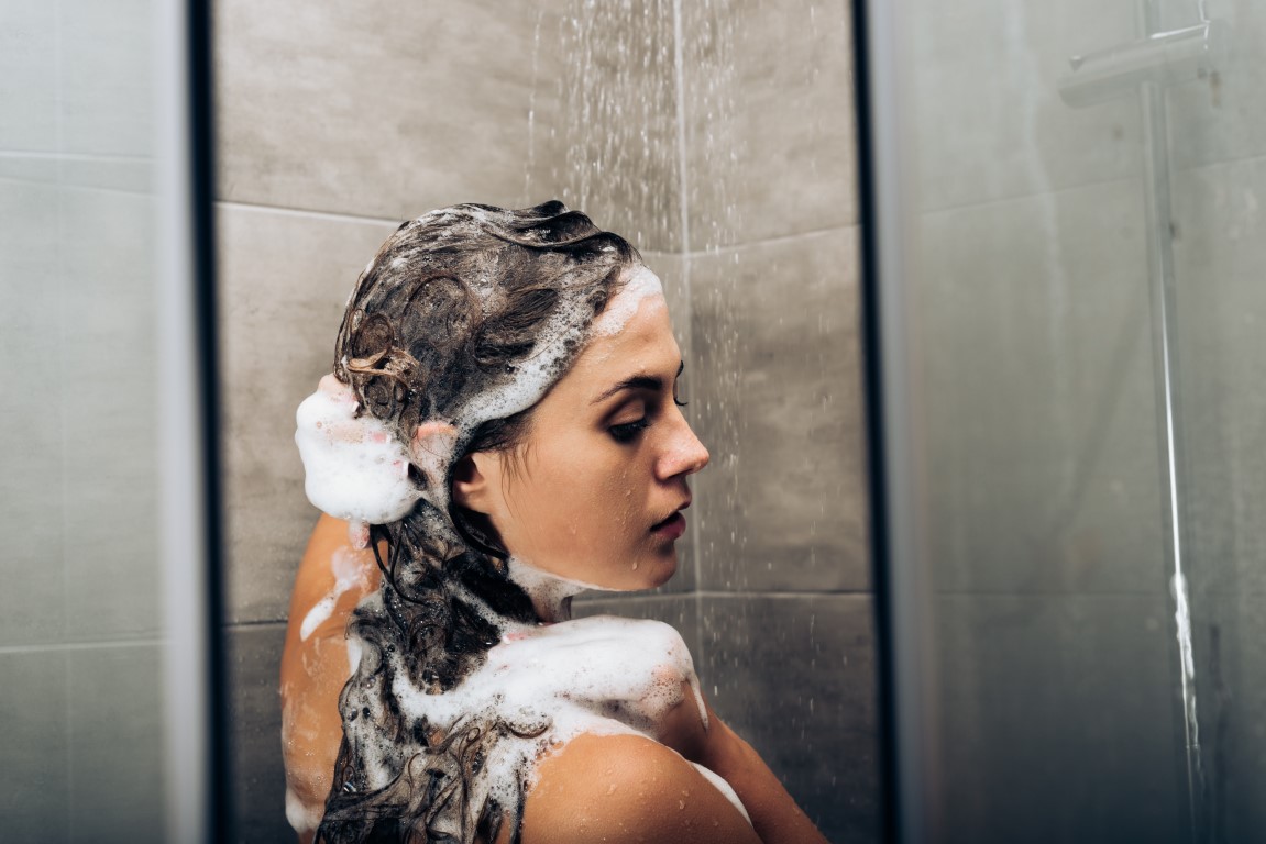 girl-washing-hair-with-shampoo-in-a-glass-shower-c-YHV8BA9