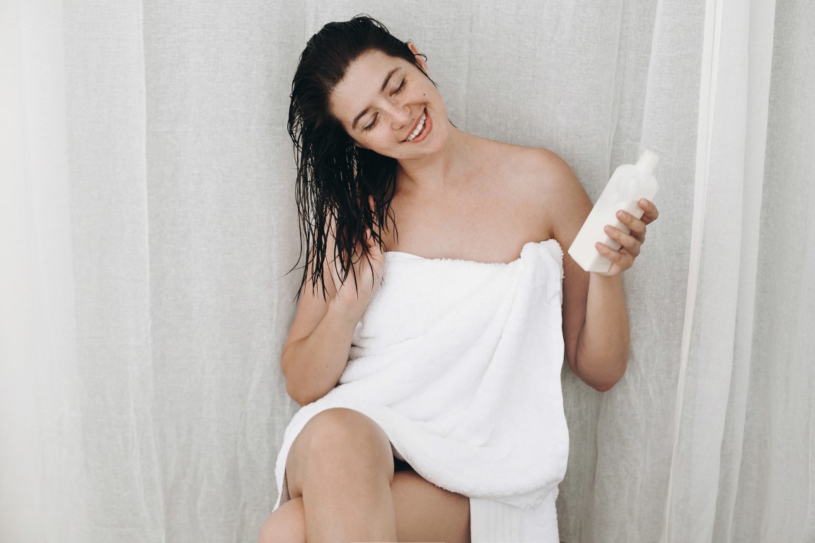 young-happy-woman-in-white-towel-holding-condition-P22NVW6