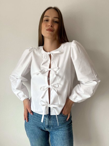 blúzka na viazanie v bielej farbe s dlhými rukávmi na modelke s dzínami