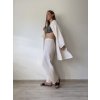 mušelínové kimono šaty v maslovej farbe  s mušelínovými dlhými letnými nohavicami na modelke pred bielou stenou