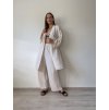 mušelínové kimono šaty v maslovej farbe  s mušelínovými dlhými letnými nohavicami na modelke pred bielou stenou