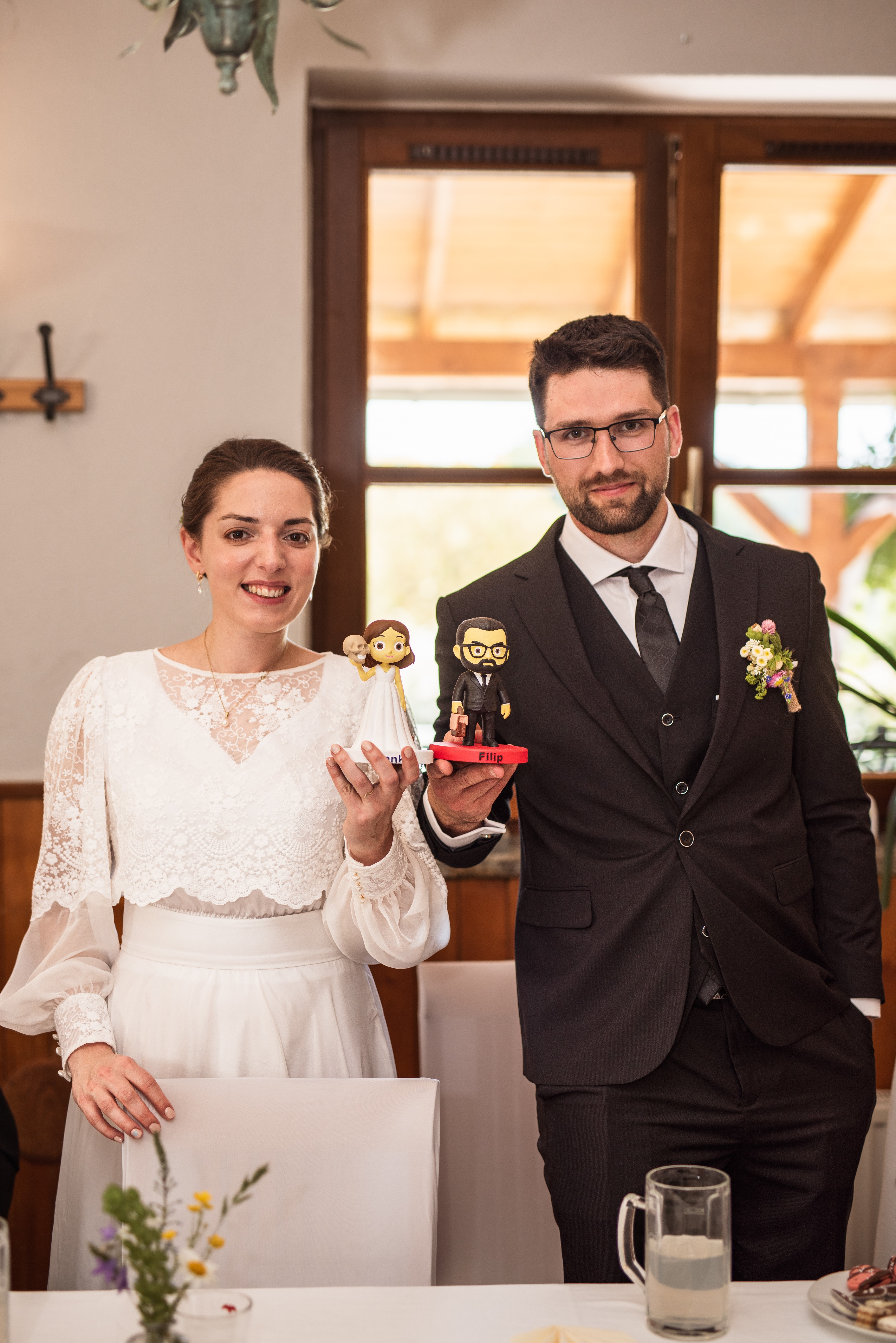 Novomanželé drží své svatební figurky na míru