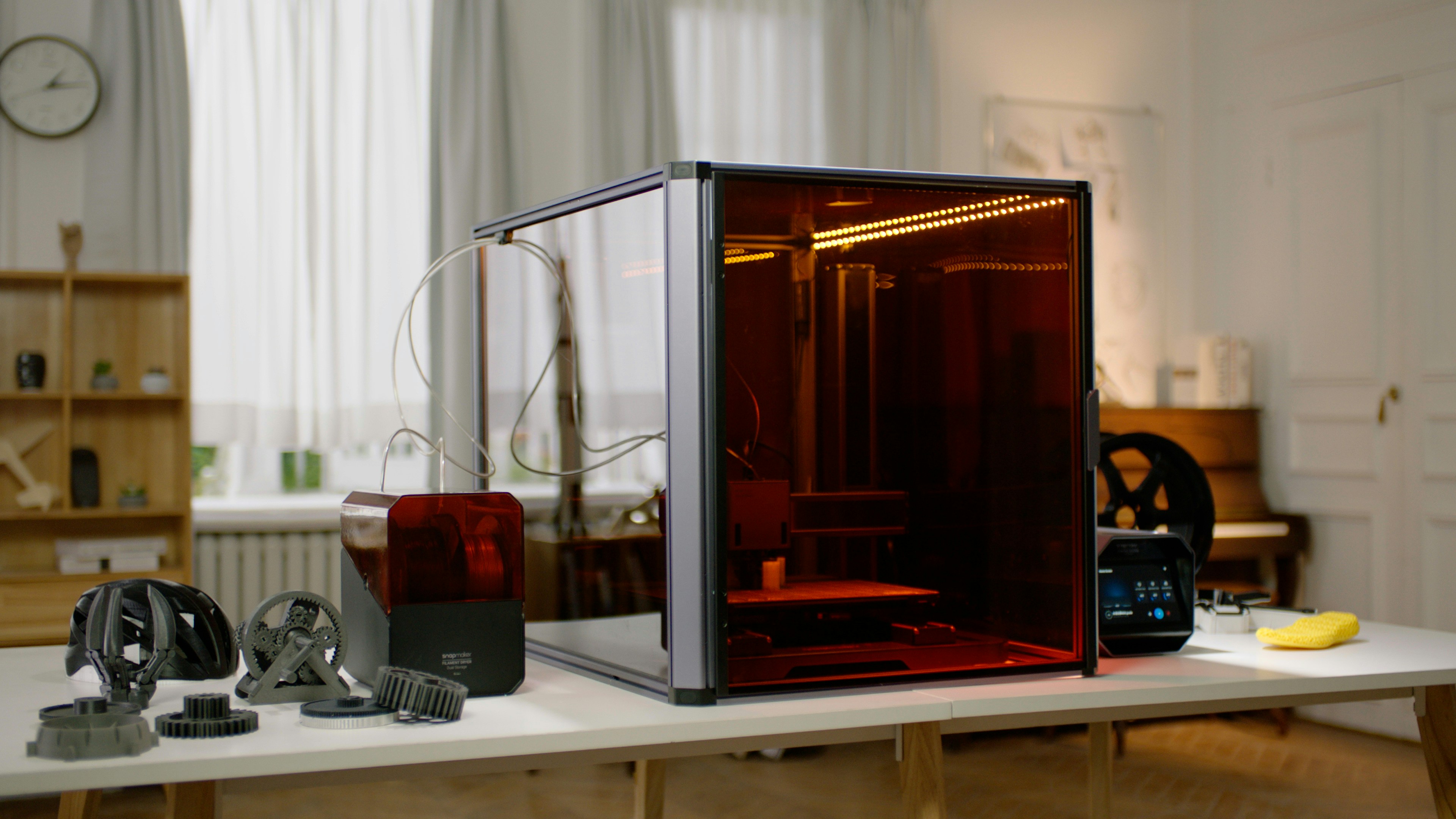 Uzavřená 3D tiskárna s tištěnými díly na stole