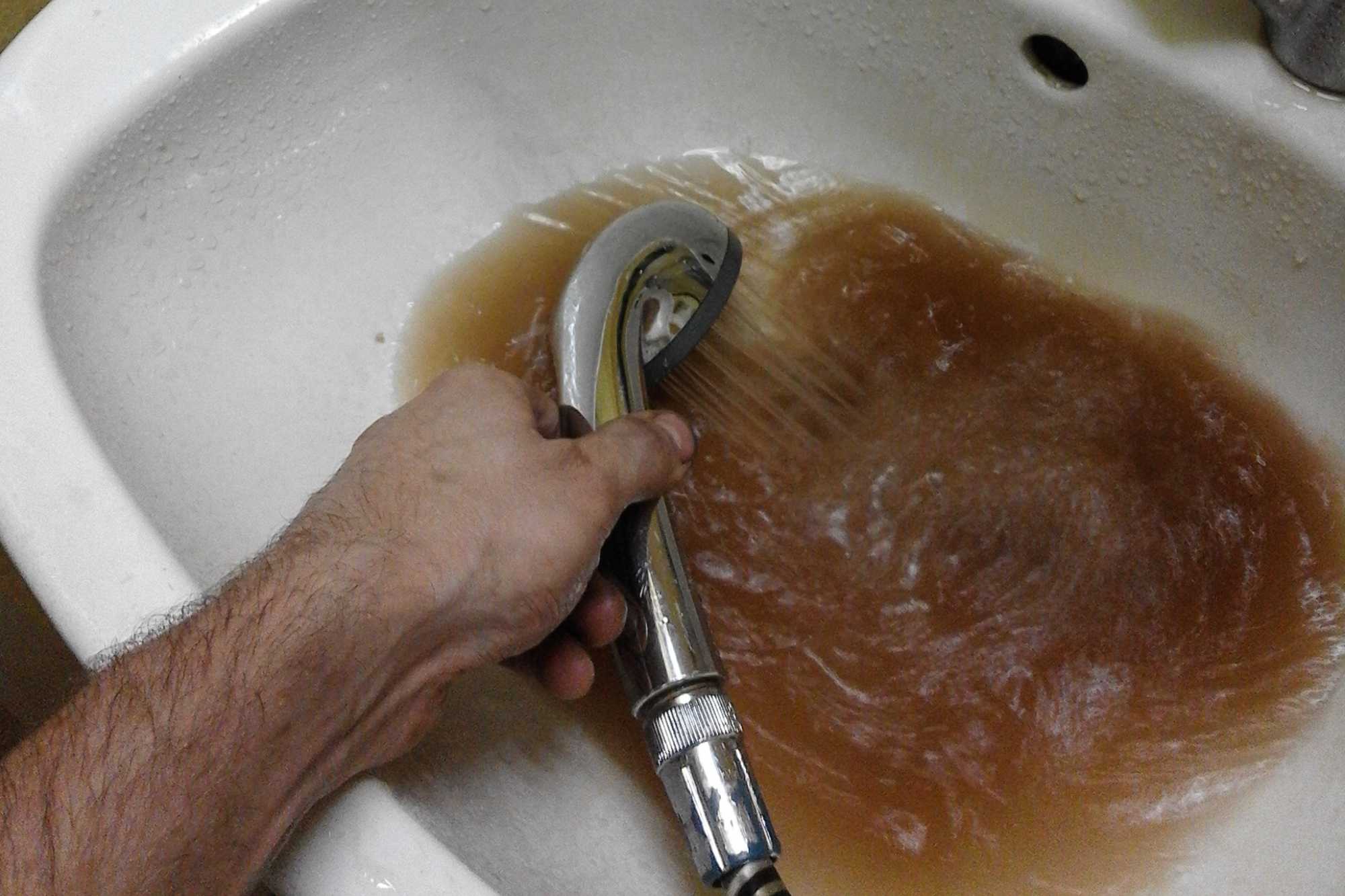 Žltoh-hnedá voda vytekájúca zo sprchy 