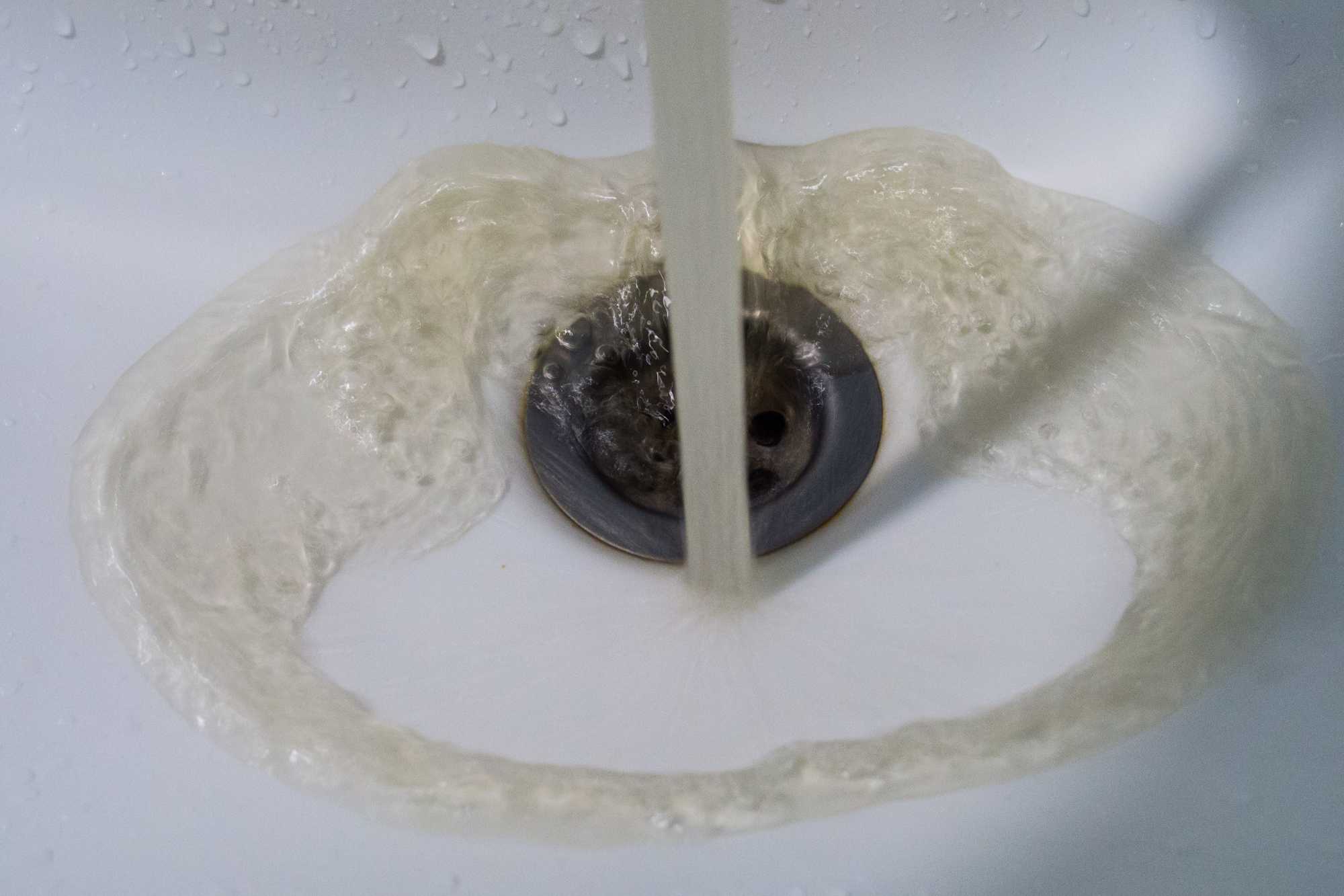 Hnedá voda vytekajúca do umývadla