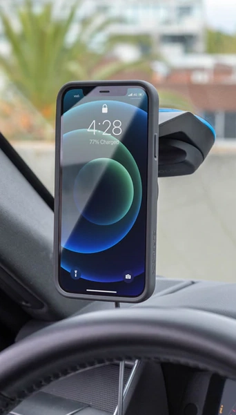 Telefon v pouzdře Quad Lock se nabíjí v dobíjecí hlavici v držáku na palubní desce auta