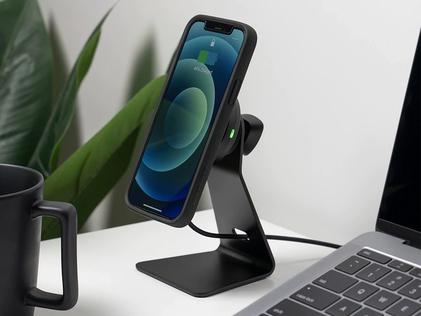 Telefon v dobíjecí hlavici Quad Lock ve stolním držáku vedle notebooku
