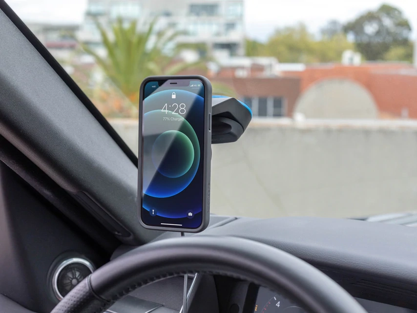 Telefon v dobíjecí hlavici Quad Lock v držáku na palubní desce auta