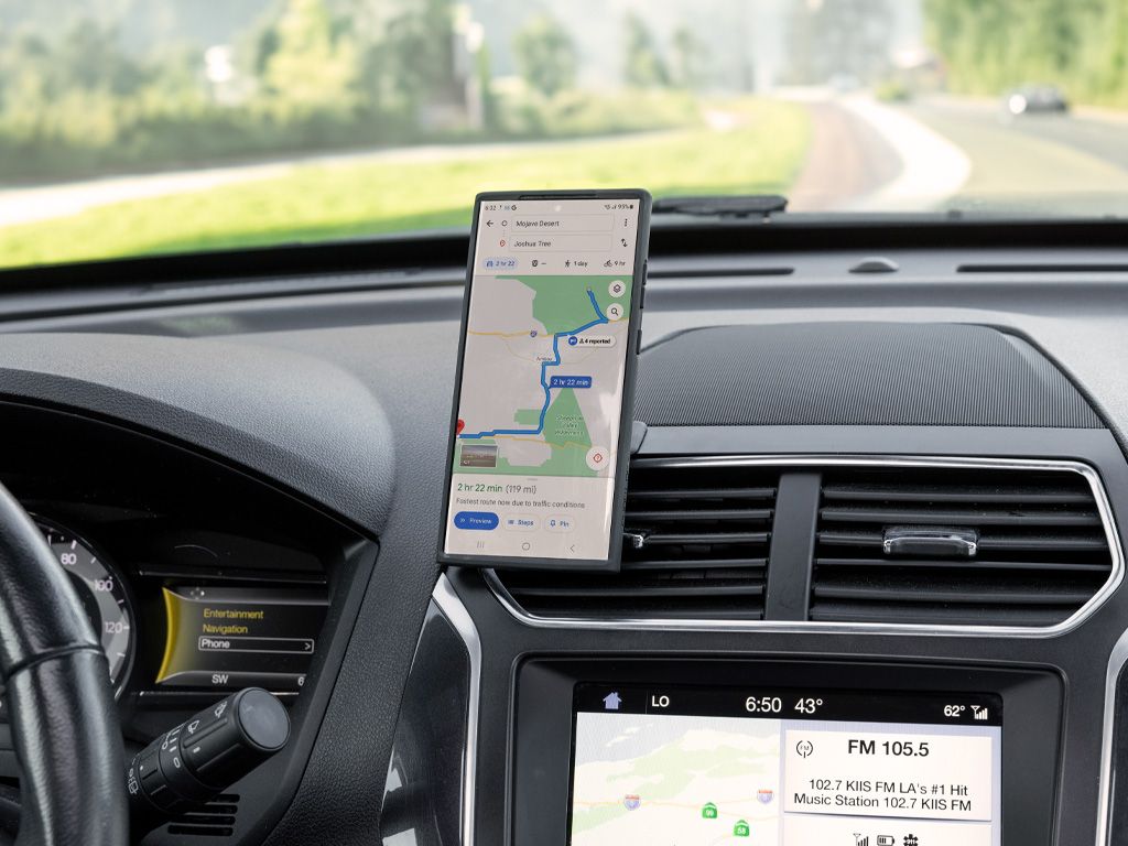 Telefon s navigací v pouzdře (prodává se zvlášť) na bezdrátové nabíjecí hlavici MAG (prodává se zvlášť) a lepicím držáku Quad Lock na palubní desce nad větracími mřížkami