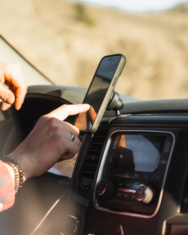 Ruka natáčí telefon v pouzdře Quad Lock (prodává se zvlášť) na kulovém kloubu lepicího držáku na palubní desce