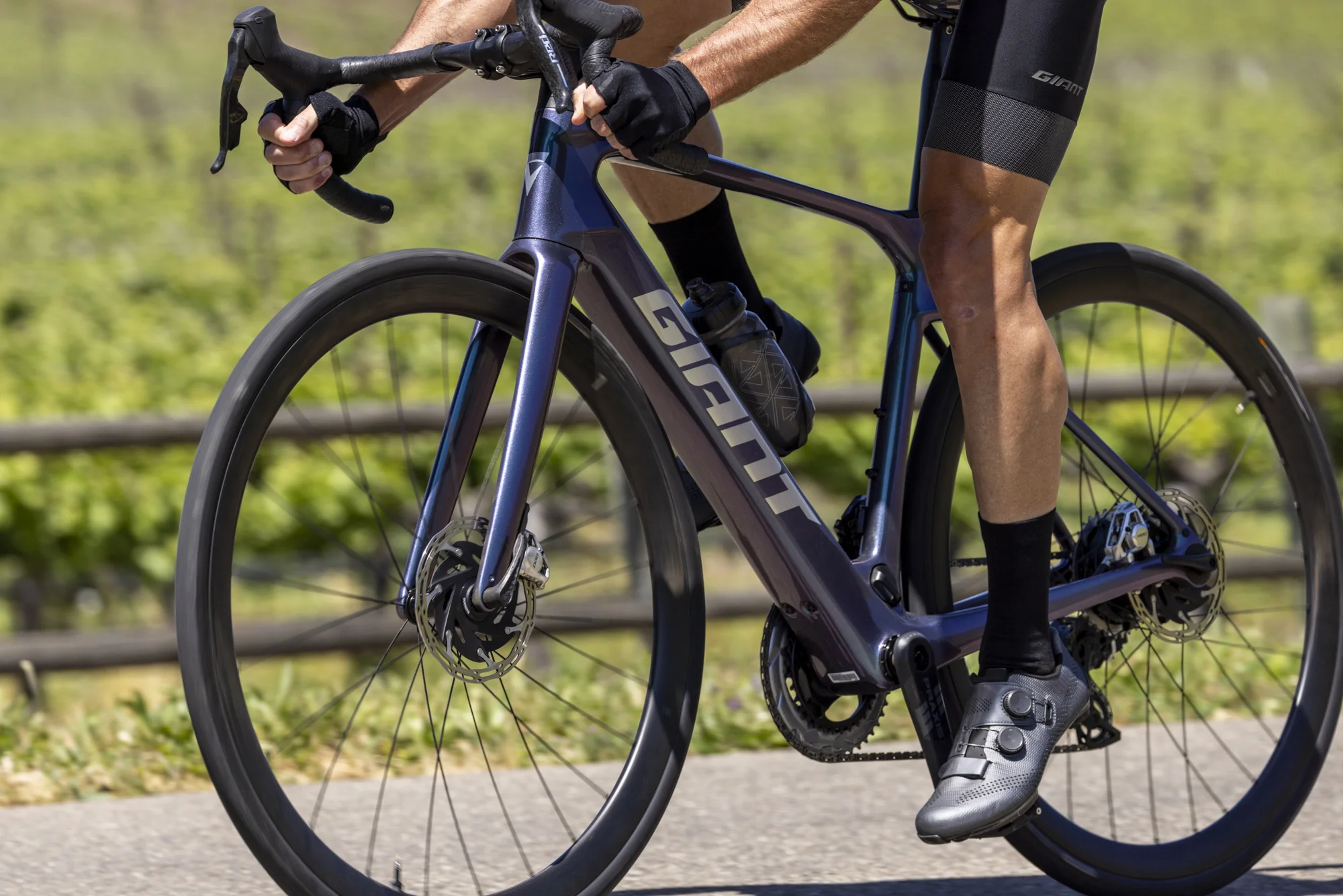 Jezdec šlape na silničním elektrokole Giant Defy Advanced E+ Elite, detail rámu a předního kola