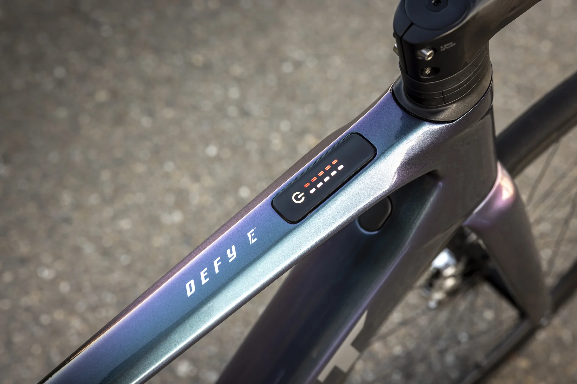 Horní trubka karbonového rámu Giant Defy Advanced E+ Elite s nápisem DEFY E a zapuštěným tlačítkem RideControl GO