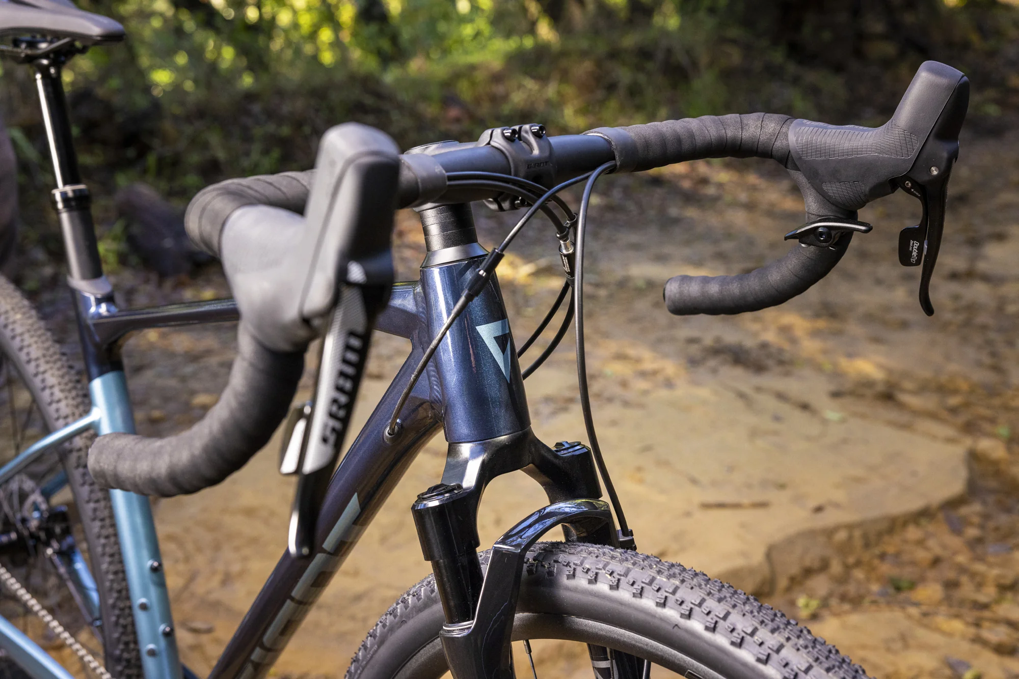 Odpružená vidlice RockShox Rudy XPLR, řídítka a páky SRAM na kole Giant Revolt X 1