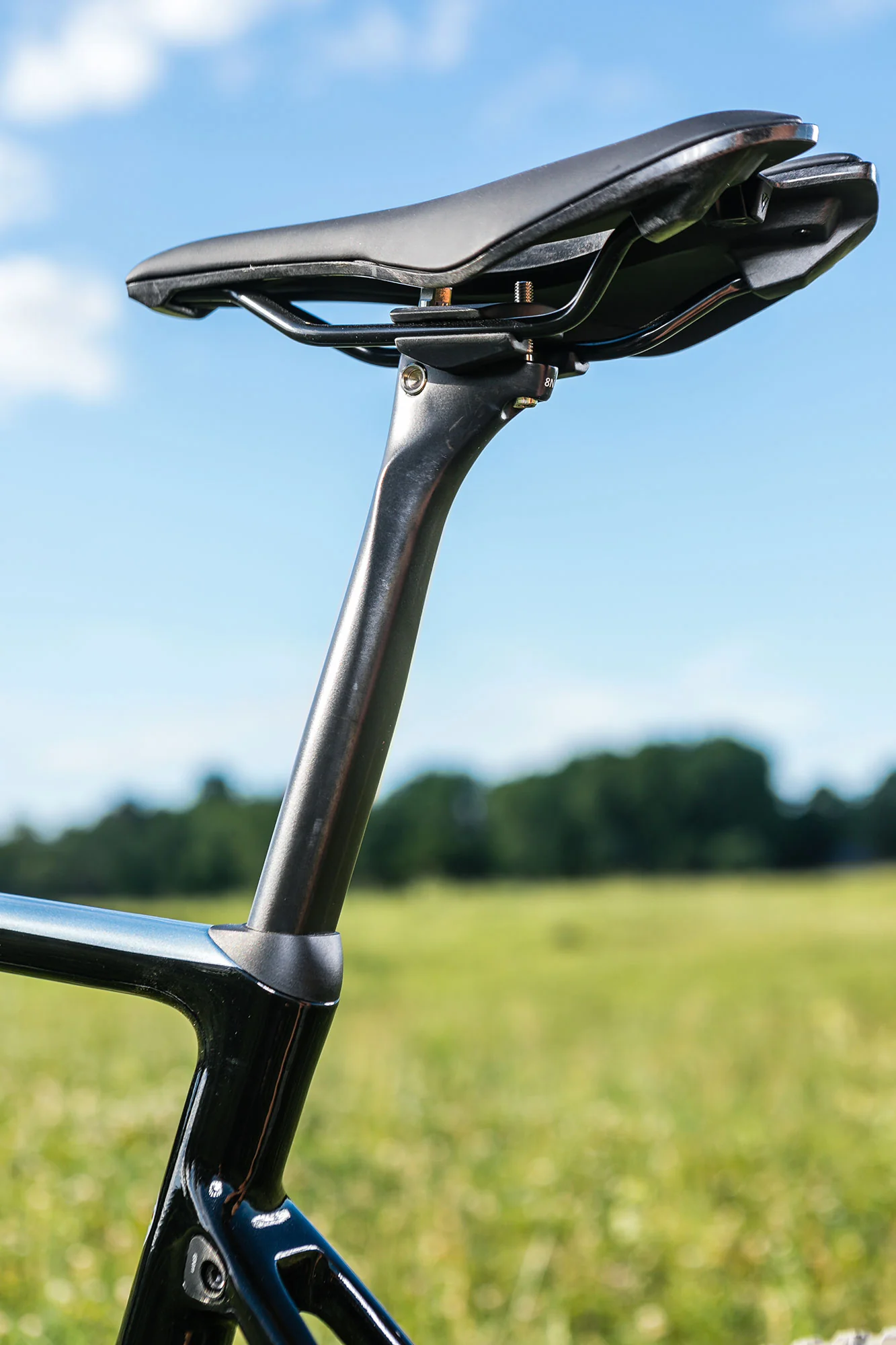 Sedlo a karbonová sedlovka kola Giant TCX Advanced Pro na pozadí louky