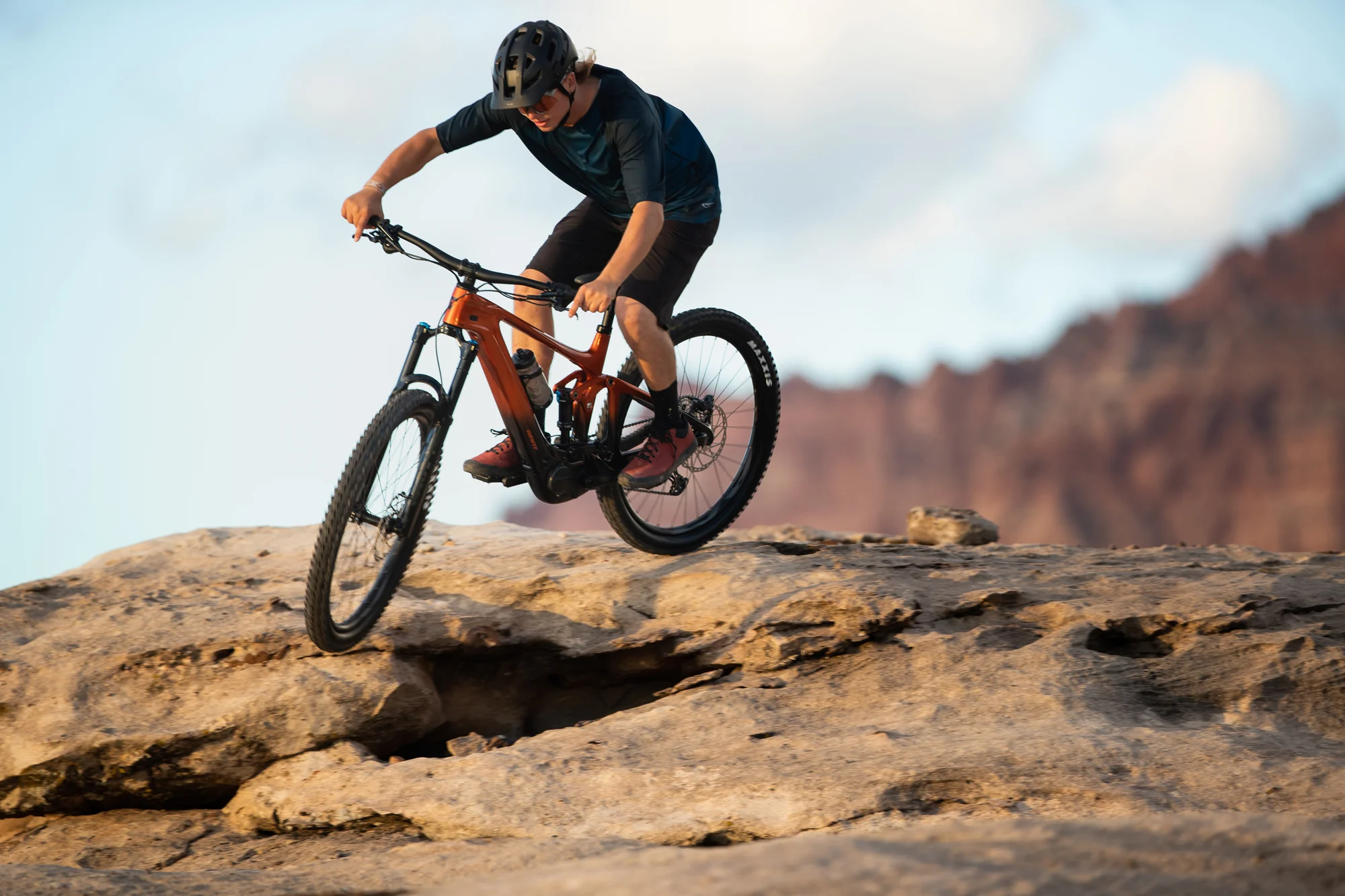 Jezdec na elektrokole Giant Trance X Advanced E+ ve skoku na skalní plošině