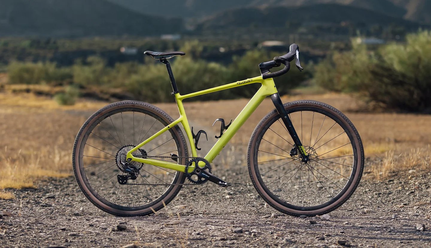 Wilier Adlar bez brašen z boku na štěrkové cestě v krajině s keři