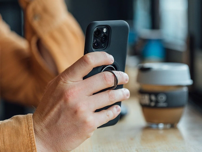 Prst provlečený kroužkem Quad Lock při držení telefonu v ruce