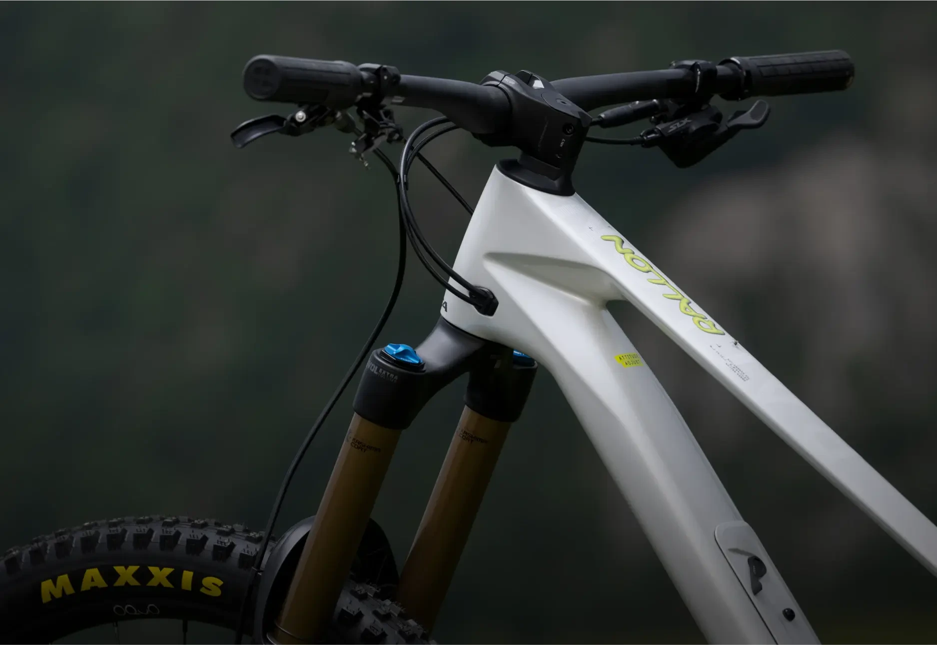 Detail hlavy rámu, řídítek a odpružené vidlice horského kola Orbea Rallon s pláštěm Maxxis