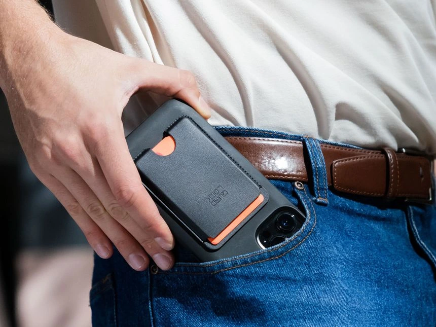 Peněženka Quad Lock MAG nasazená na zadní straně telefonu na stole