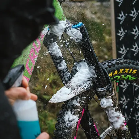 Čistič Peaty's LoamFoam nastříkaný jako pěna na vidlici a rám horského kola