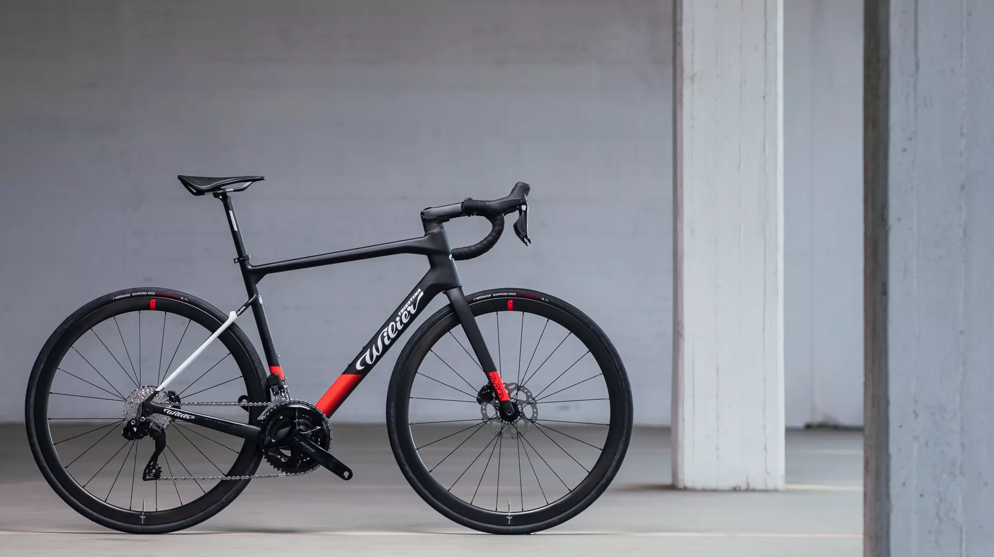 Silniční kolo Wilier Garda Disc opřené v betonové hale