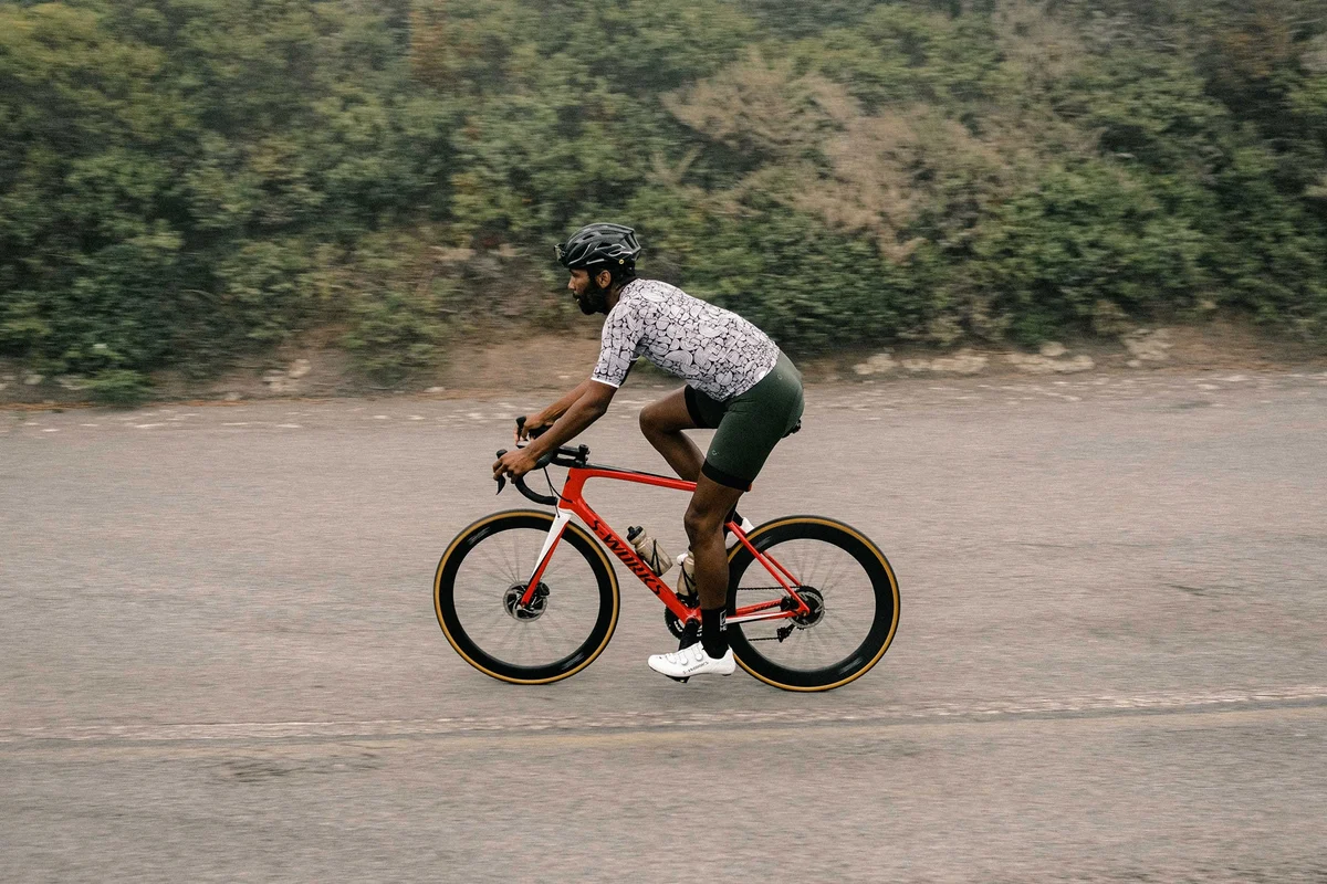 Jezdec na silničním kole S-Works s koly HUNT 65 Carbon Aero Disc při jízdě po asfaltu, pohled z boku