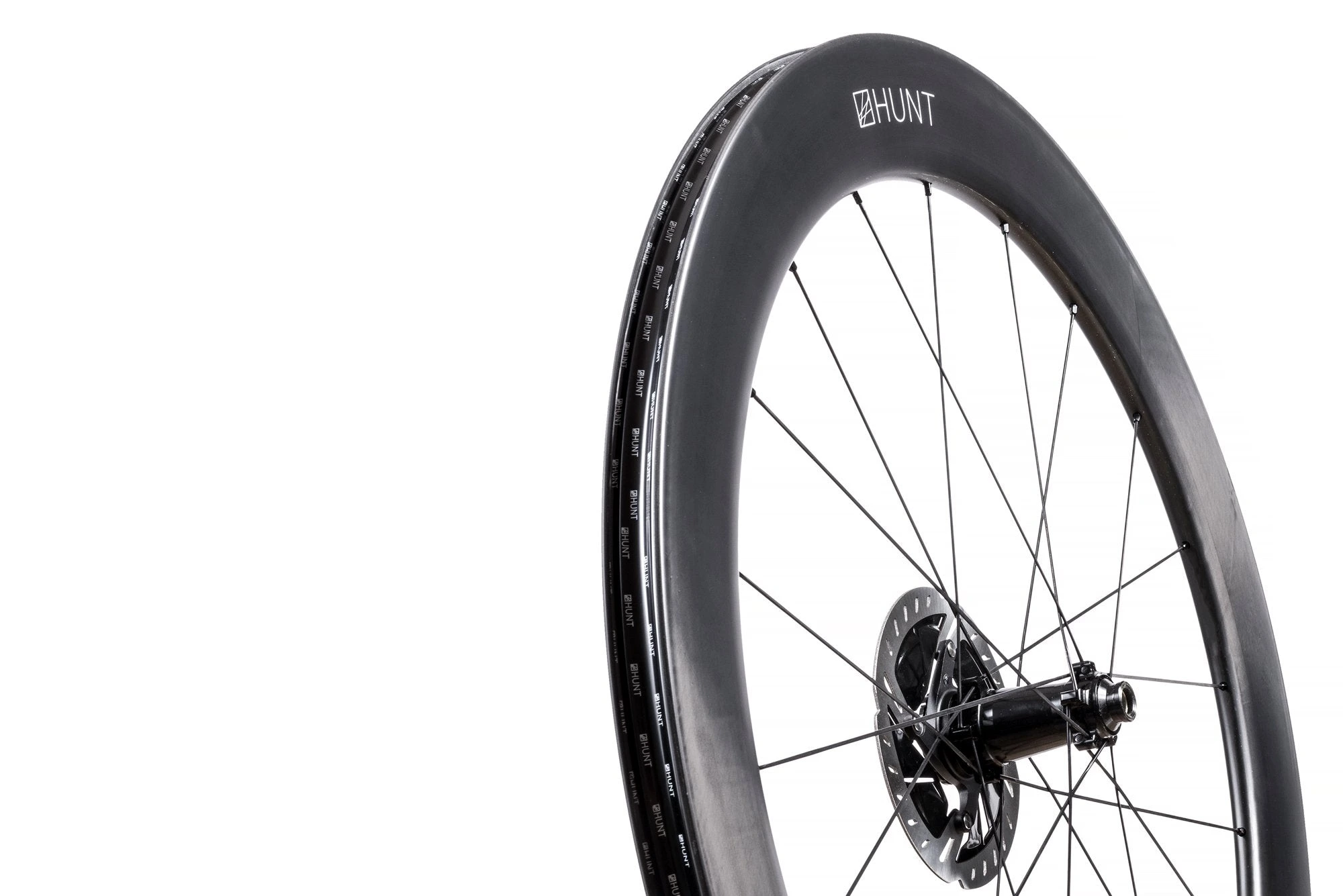 Přední kolo HUNT 65 Carbon Aero Disc s hlubokým karbonovým ráfkem, logem HUNT a brzdovým kotoučem