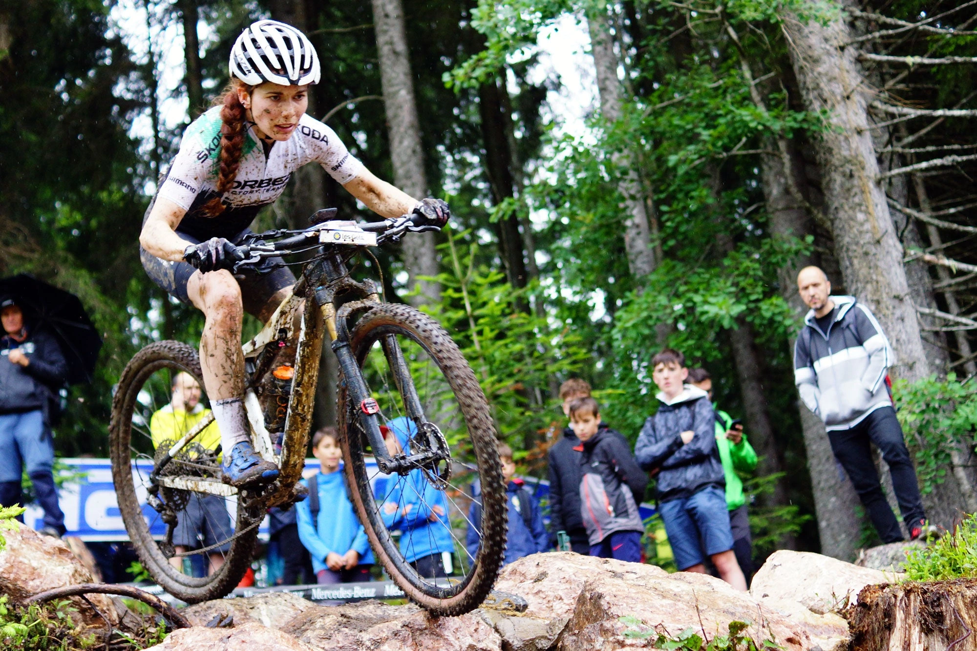 Závodnice na XC horském kole přejíždí kameny na bahnité trati, kola HUNT Race XC MTB 29